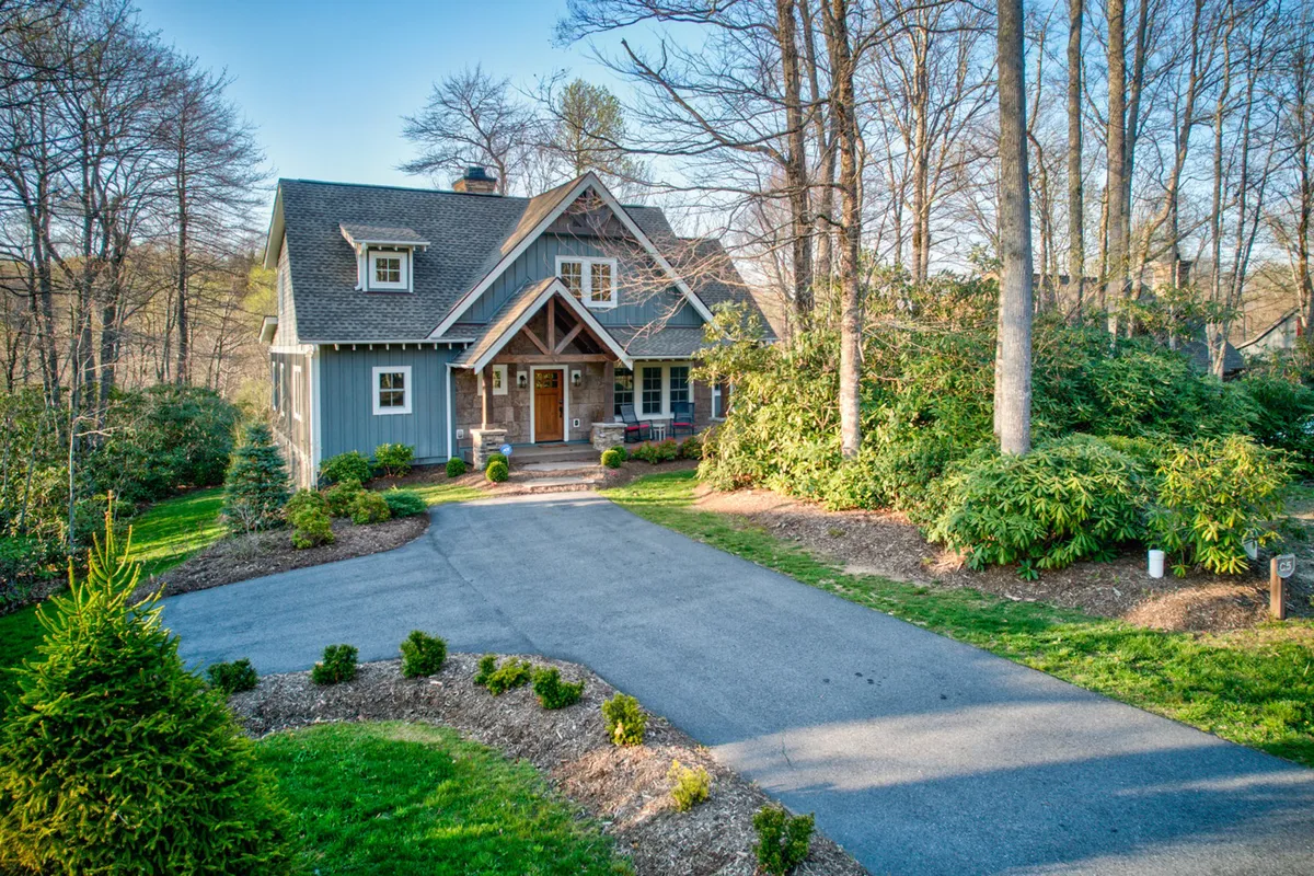 The hero image showcases the charming front exterior of Bluebird Cottage, with a welcoming front door, expansive windows that promise natural light, and a beautifully landscaped garden perfect for outdoor activities. The inviting porch hints at relaxing evenings and the spacious yard is ideal for gatherings or for children to play.